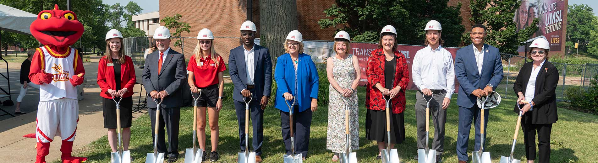 faculty and staff and a mascot with shovels