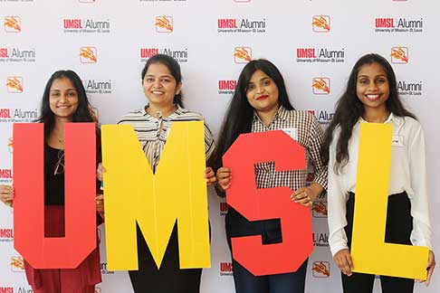 students holding large UMSL letters